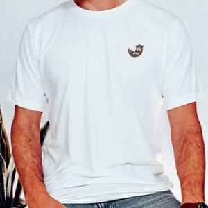 May include: A white t-shirt with a small brown otter graphic on the left chest.