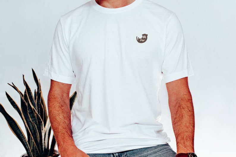 May include: A white t-shirt with a small brown otter graphic on the left chest.