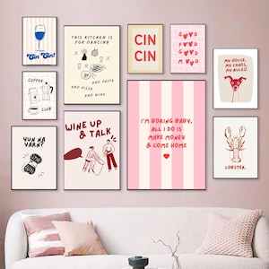 May include: A collection of framed art prints with various designs and text. The prints feature illustrations of a wine glass, coffee, a dog, a lobster, and text like "Gin Gin!", "This kitchen is for dancing", and "I'm boring baby".