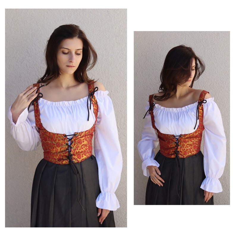 Pu&ograve; includere: Un corpetto in broccato rosso e oro con lacci e bretelle neri. Il corpetto &egrave; indossato sopra una blusa contadina bianca e una gonna nera.