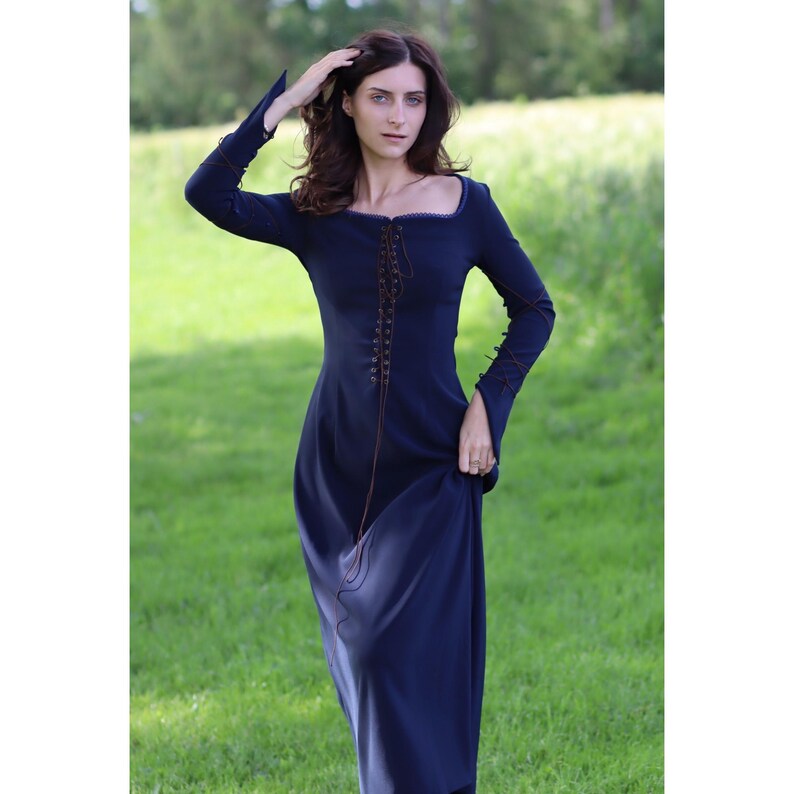 May include: A long-sleeved, navy blue dress with a lace-up bodice and a fitted waist. The dress has a square neckline and long sleeves with a slight puff at the shoulders.