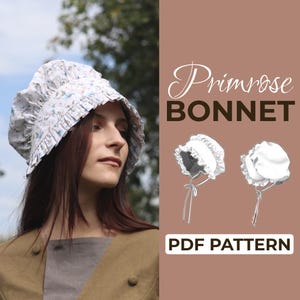 May include: A woman wearing a white bonnet with a floral pattern. The bonnet has a ruffled brim and is tied with a ribbon. The text "Primrose BONNET" and "PDF PATTERN" are displayed on a brown background.