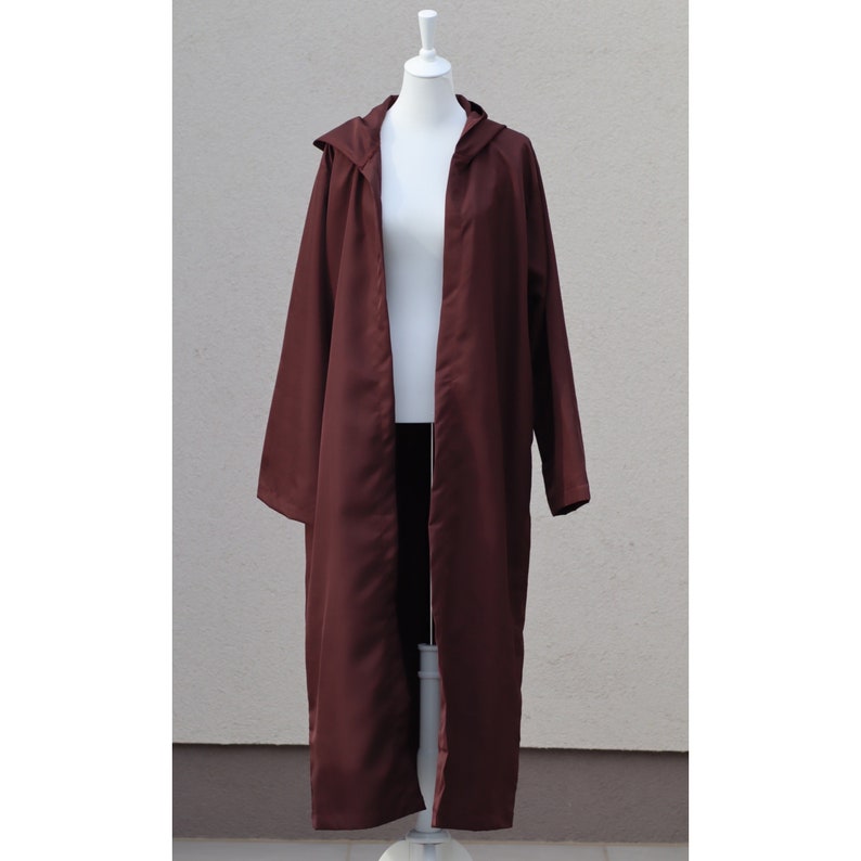 May include: A long, maroon hooded robe with a long, open front. The robe is made of a smooth, silky fabric.