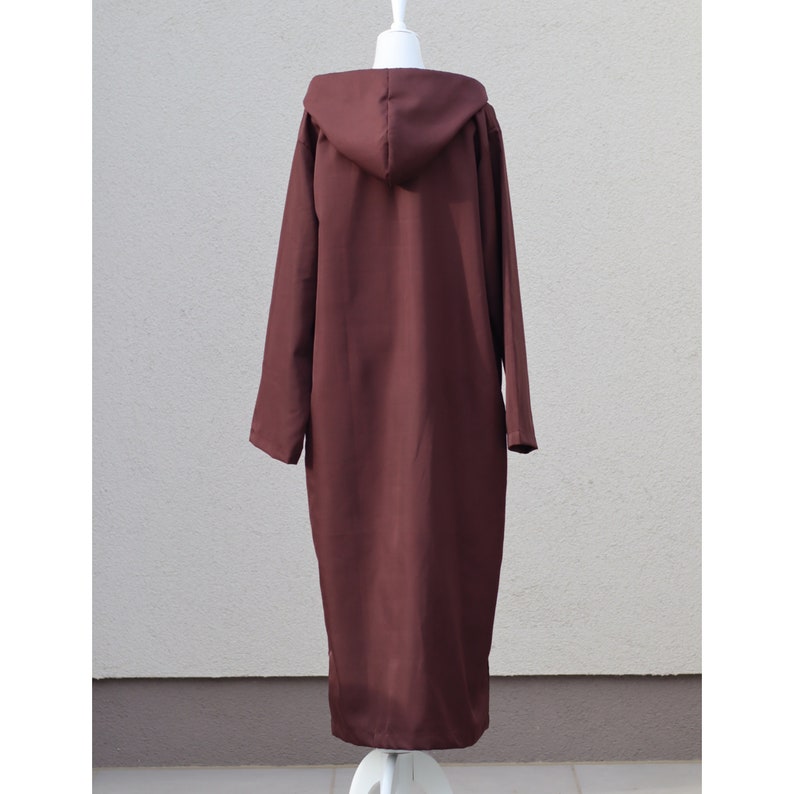 May include: A long, brown hooded robe with a simple design. The robe is made of a soft, smooth fabric.