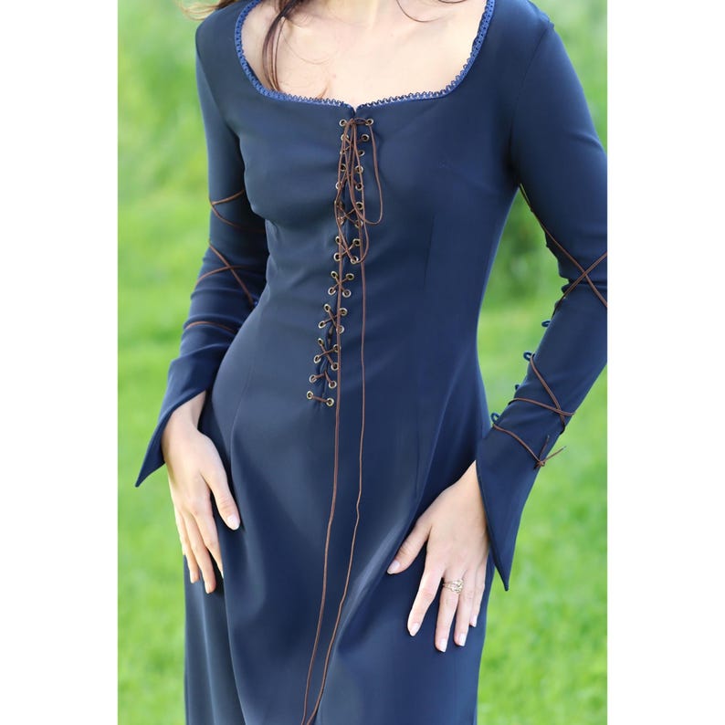 May include: A long-sleeved, navy blue dress with a lace-up front and brown laces. The dress has a square neckline and a fitted bodice.