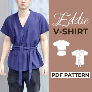 Può includere: Una maglietta blu navy con scollo a V e cintura avvolgente in vita. La maglietta è a maniche corte e ha una vestibilità rilassata. Il testo "Eddie V-SHIRT" e "PDF PATTERN" sono visibili.