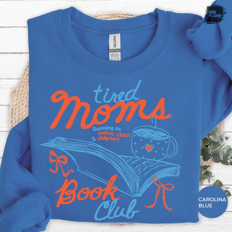 May include: Carolina blue sweatshirt with the words "tired Moms Book Club" in orange and blue. The design includes a coffee cup with a heart and an open book with bows.