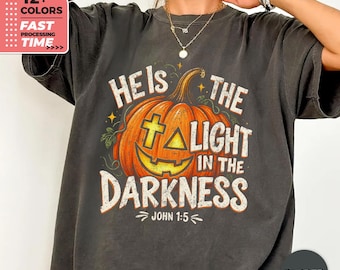 T-shirt « Il est la lumière dans les ténèbres » – T-shirt chrétien d'Halloween, Jean 1:5 – T-shirt de foi