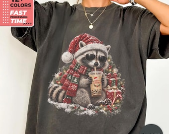 Maglietta natalizia con procione e colori confortevoli – Maglietta divertente per le feste, maglietta con Babbo Natale e procione, maglietta festiva con bubble tea