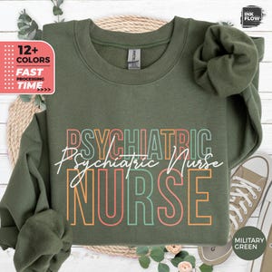 May include: A green sweatshirt with the text "PSYCHIATRIC Psychiatric Nurse NURSE" in rainbow colors. The text is in a retro style font.