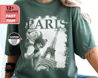 May include: A green t-shirt featuring a black and white photograph of the Eiffel Tower with a couple in front of it. The text "PARIS" and "June 2020" is printed on the shirt.