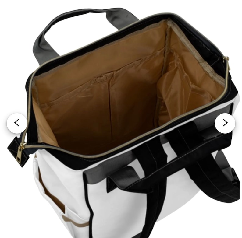 May include: A white and black backpack with a zipper closure and a brown interior. The backpack has multiple pockets and a padded back.