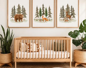 May include: Three framed wall art prints featuring watercolor illustrations of forest animals. The first print shows a brown bear, the second a fox and hedgehog, and the third a deer and fawn, all set against a backdrop of green pine trees.