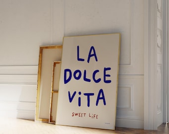 May include: A white canvas print with a gold frame featuring the text "LA DOLCE VITA" in blue lettering and "SWEET LIFE" in red lettering.