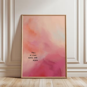 May include: Framed art print with a soft, abstract design in shades of pink, peach, and white. The artwork features the text "FALL IN LOVE AGAIN AND AGAIN" in a simple black font, creating a romantic and inspirational piece.