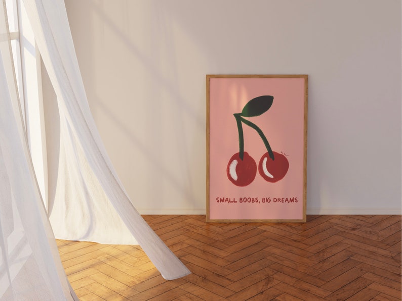 K&ouml;nnte beinhalten: Ein rosa Poster mit einer Grafik von zwei roten Kirschen und dem Text "SMALL BOOBS, BIG DREAMS".