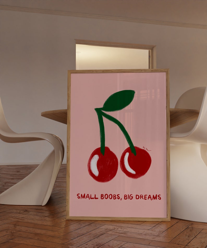 K&ouml;nnte beinhalten: Ein gerahmtes rosa Poster mit einem gr&uuml;nen Stiel und zwei roten Kirschen. Der Text "SMALL BOOBS, BIG DREAMS" ist unter den Kirschen gedruckt.