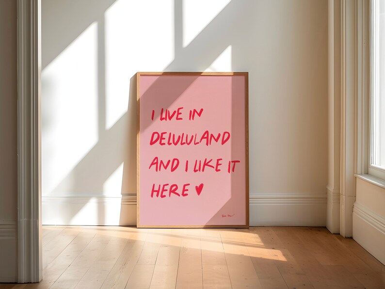 以下が含まれることがあります： 赤い文字で「I live in Lululand and I like it here &hearts;」と書かれたピンクのポスターが額縁に入っています。