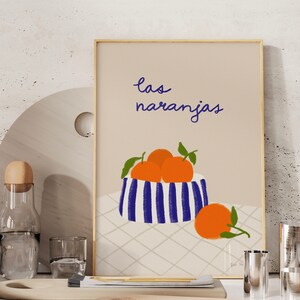 May include: A printable art print with a blue and white striped bowl filled with orange fruit. The text "las naranjas" is written in blue cursive script above the bowl.