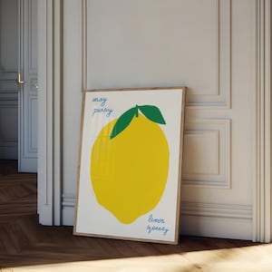 Może przedstawiać: Wydruk w ramie z ilustracją żółtego cytryna i tekstem "easy peasy lemon squeezy" w niebieskich i zielonych literach.