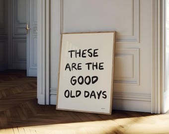 May include: A framed print with the text "These are the good old days" in black handwritten font on a white background.