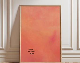 May include: Framed art print with a warm, blended color palette of peach, orange, and pink hues. The artwork features the phrase "THIS IS MY HAPPY PLACE" in black, handwritten-style text. The frame is a light brown color.
