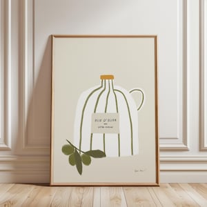 Op de afbeelding: Een ingelijste kunstdruk met een witte olijfoliekan met groene strepen en een gouden dop. Het etiket luidt "OLIO D'OLIVA EXTRA VERGINE". Een takje olijven staat eronder. De achtergrond is lichtbeige.