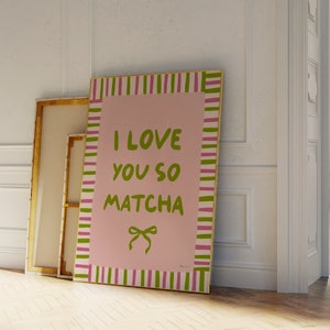 May include: A pink and green striped framed canvas print with the text "I love you so matcha" in green lettering and a green bow.