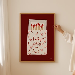May include: A red background with a white box of matches. The box is wrapped in a red and white candy cane pattern with red bows. The text "holly jolly" is written in red on the box.