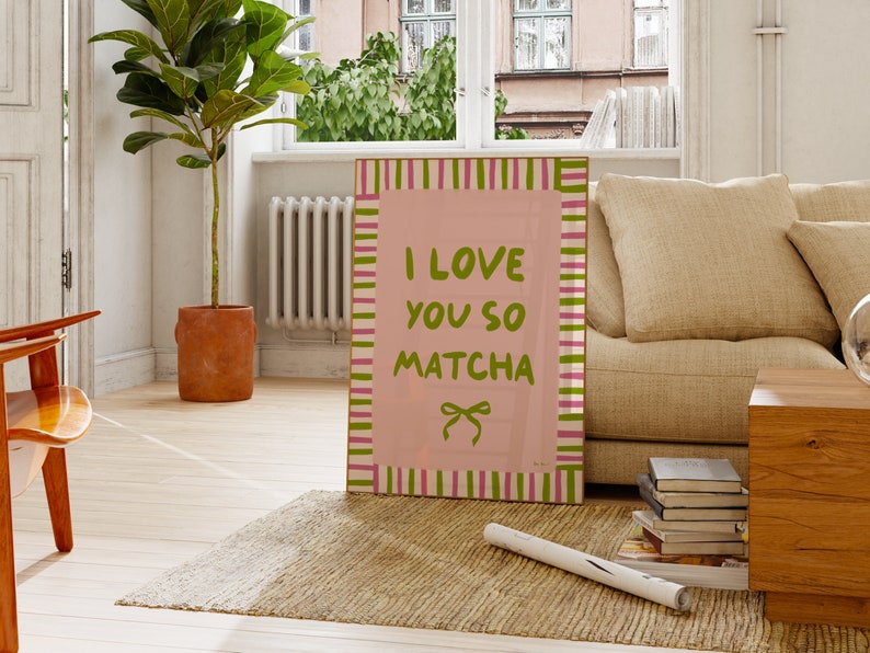 May include: Pink and green striped poster with the text "I love you so matcha" in green letters. The poster has a pink ribbon with a bow on it.