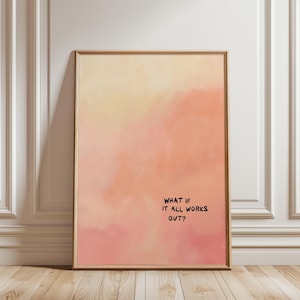 May include: Framed art print with a watercolor-style background in shades of peach, pink, and yellow. The black text reads, "WHAT IF IT ALL WORKS OUT?" The artwork is displayed in a wooden frame.