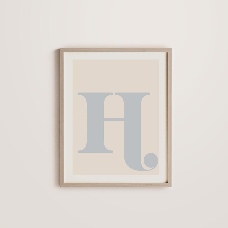 May include: A framed print featuring a light beige background with a large, grey letter "H" in a stylised font.