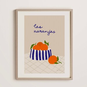 May include: A print of a still life featuring a bowl of oranges with the text "las naranjas" in blue cursive.
