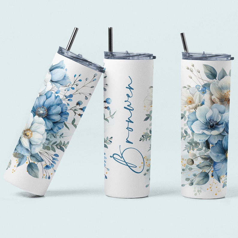 May include: Three stainless steel tumblers with a white background and blue floral designs. The tumbler in the centre has the name "Brooklyn" written in cursive on it.
