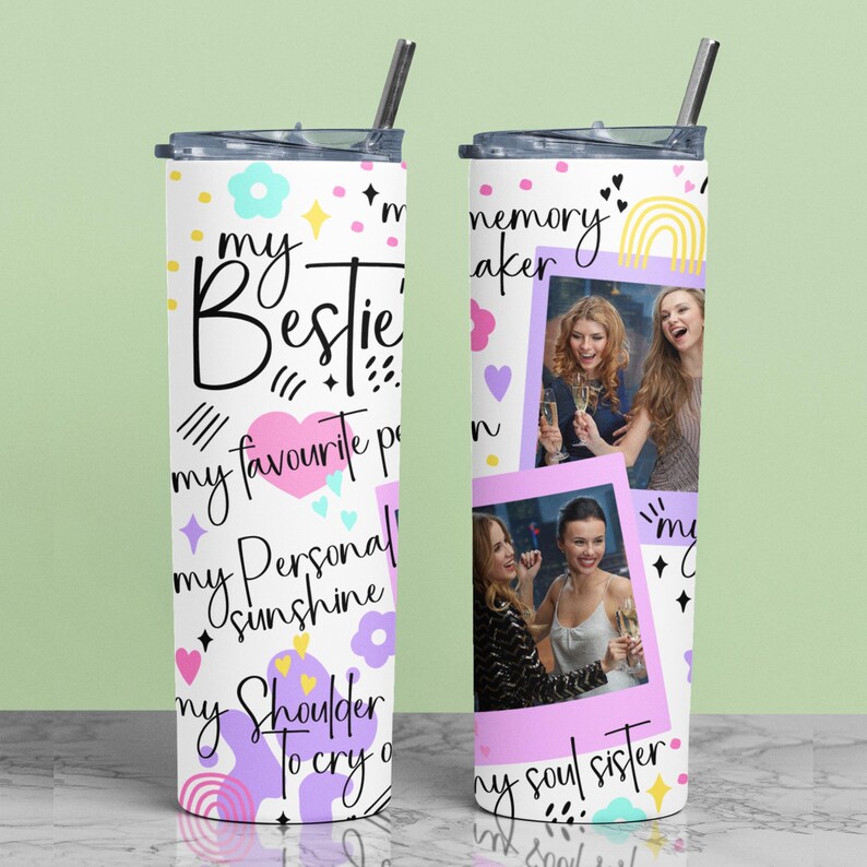 May include: A white tumbler with a black lid and straw, decorated with the words "my Bestie" and other phrases. It features a pink heart, flowers, and photos of three women. The tumbler is designed for cold beverages.