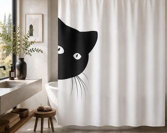 May include: A white shower curtain featuring a large, black graphic of a cat head peeking from the left side. The design includes two white eyes and thin, black whiskers extending from the cat's muzzle onto the plain white fabric background.