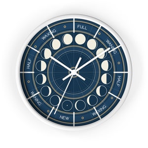 May include: A round wall clock with a white frame and a dark blue face featuring a lunar cycle diagram. The dial displays moon phases in cream, with text labels including WAXING, FULL, WANING, HALF, and NEW. Three white clock hands are centered.