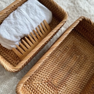 Peut inclure: Deux paniers en osier tress&eacute;, l'un contenant une serviette blanche et un peigne en bois. Les paniers sont rectangulaires et de couleur brun naturel.