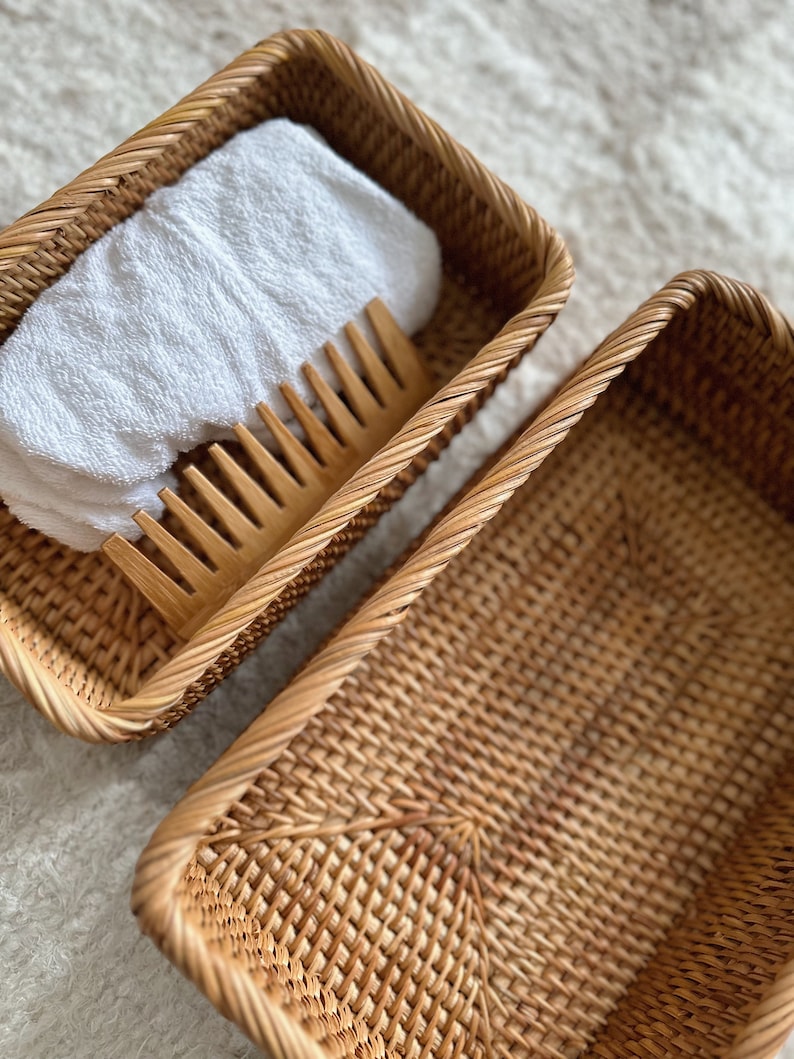 Peut inclure: Deux paniers en osier tress&eacute;, l'un contenant une serviette blanche et un peigne en bois. Les paniers sont rectangulaires et de couleur brun naturel.