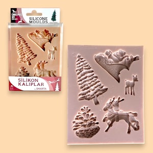 Peut inclure: Un moule en silicone rose avec des motifs sur le thème de Noël. Le moule présente un sapin de Noël, un renne tirant un traîneau, une pomme de pin et un renne. Le moule est étiqueté "SILIKON KALIPLARI by SMARTA".