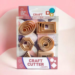 Könnte beinhalten: Eine transparente Kunststoffverpackung mit Ausstechern in verschiedenen geometrischen Formen. Die Ausstecher sind beige und umfassen Ovale, Rechtecke, Sechsecke, Kreise und Dreiecke. Die Verpackung trägt die Aufschrift "Craft Cutter by Smarta" und "Geometric Cutters".