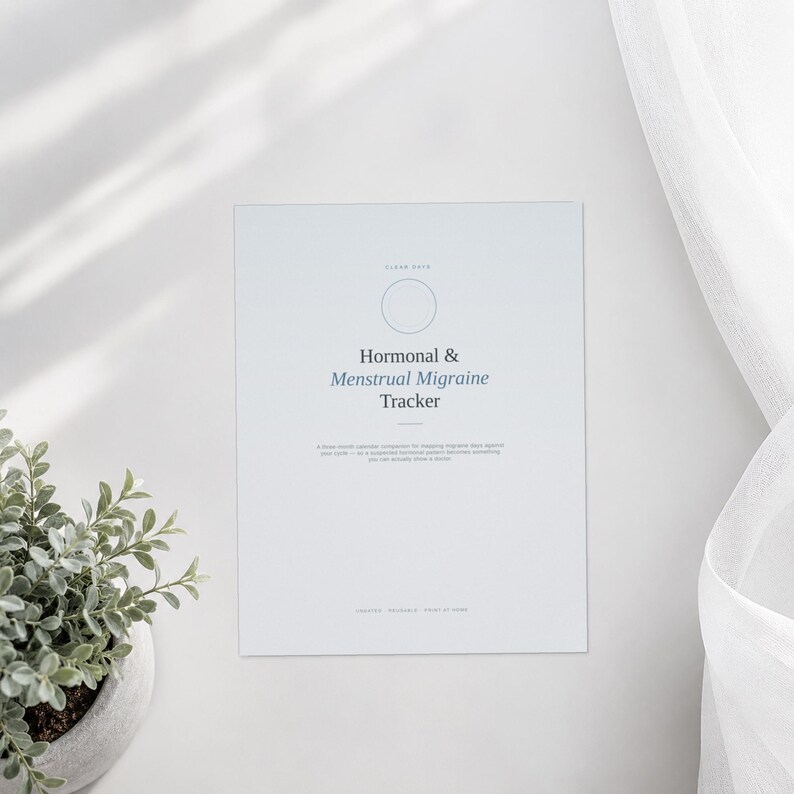 Op de afbeelding: Een wit papieren tracker getiteld Hormonal & Menstrual Migraine Tracker met een cirkelvormig icoon bovenaan. De tekst bevat een kalendervergelijking van drie maanden voor het bijhouden van migrainedagen ten opzichte van de cyclus en merkt op dat een patroon iets wordt dat je aan een arts kunt laten zien.