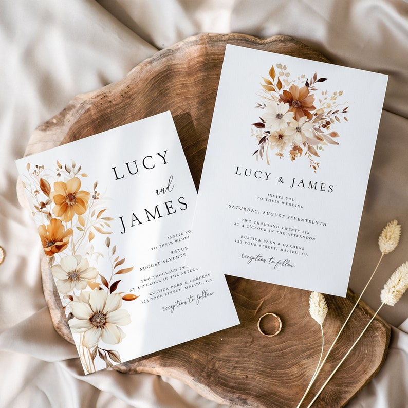 Pode incluir: Dois convites de casamento com um design floral em tons de marrom, bege e branco. Os convites s&atilde;o impressos em papel&atilde;o branco e apresentam os nomes "Lucy & James" e a data do casamento "S&aacute;bado, 17 de agosto de 2026".