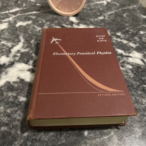 May include: A maroon hardcover book titled "Elementary Practical Physics" by Black and Davis. The book has a revised edition label and features a white airplane flying upwards on the cover.