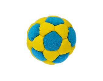 Könnte beinhalten: Ein gelber und blauer Fussball aus weichem Stoff. Der Ball hat eine strukturierte Oberfläche und ist zum Spielen gedacht.