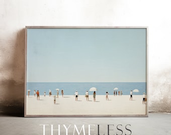 May include: A framed print of a beach scene with people standing on the sand under white umbrellas. The sky is a light blue and the water is a darker blue. The sand is white. The print is in a silver frame.
