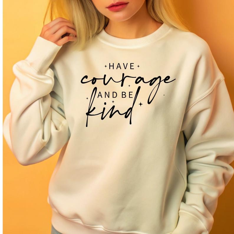 May include: White sweatshirt with black text that reads "Have courage and be kind".