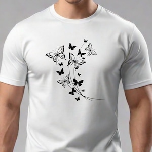 Puede incluir: Camiseta blanca con un dise&ntilde;o de mariposa negra. Las mariposas est&aacute;n agrupadas y parecen estar volando hacia arriba.