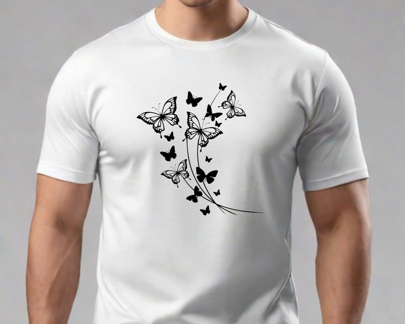 Puede incluir: Camiseta blanca con un dise&ntilde;o de mariposa negra. Las mariposas est&aacute;n agrupadas y parecen estar volando hacia arriba.