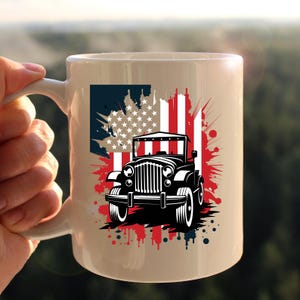 May include: A white ceramic mug with a black and white illustration of a jeep driving through a red, white, and blue American flag. The flag is stylized with paint splatters.
